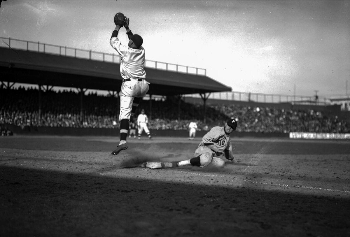 April 7, 1925: Angels' first baseman Ray Grimes leaps high during a pickoff attempt of the Portland Beavers' Charley High in the season opener at Washington Park. The throw was from Angels catcher Gus Sanberg.