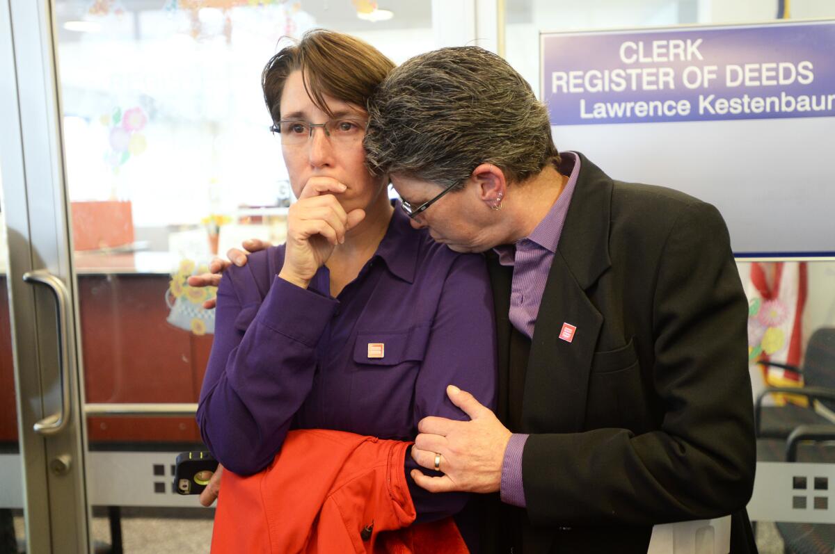Dana Bauer, right, comforts partner Tracy Pennington after the couple learned they would not be able to apply for a marriage license Wednesday in Ann Arbor, Mich.