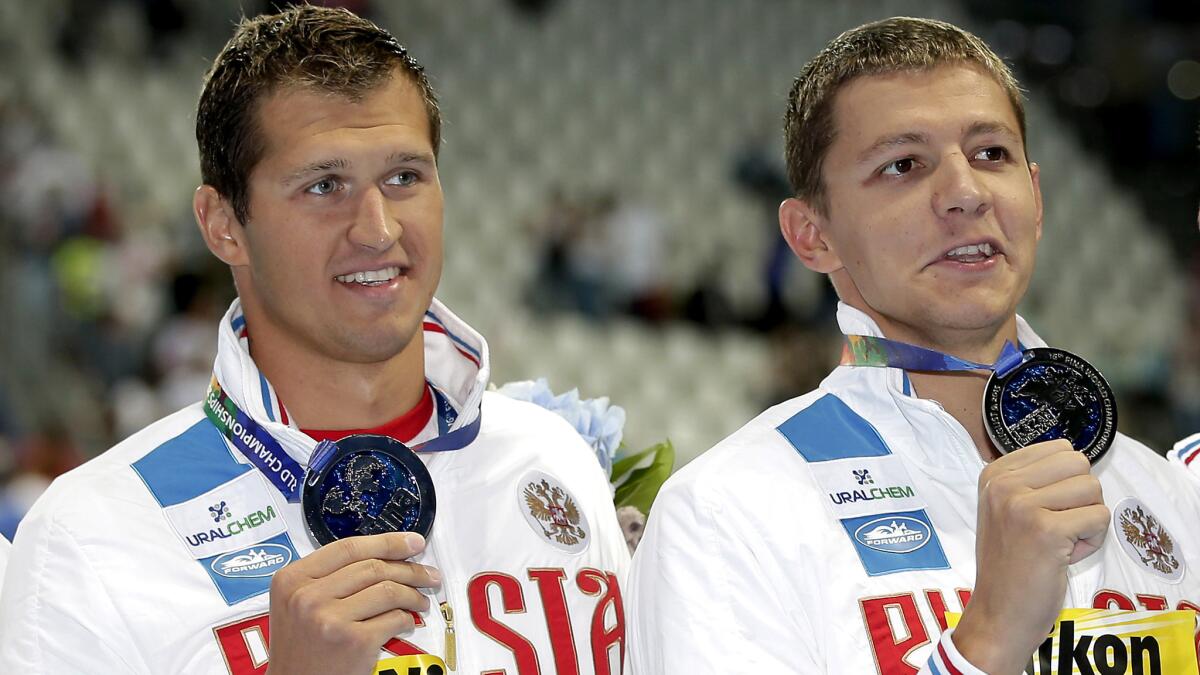 Nikita Lobintsev, left, and Vladimir Morozov pose with their silver medals after helping Russia to second place in the 800-meter freestyle relay at the 2015 world championships.