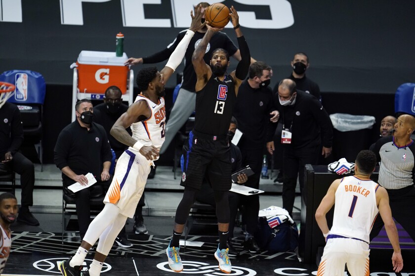 Clippers forward Paul George takes a shot over Suns center Deandre Ayton on April 8 at Staples Center.