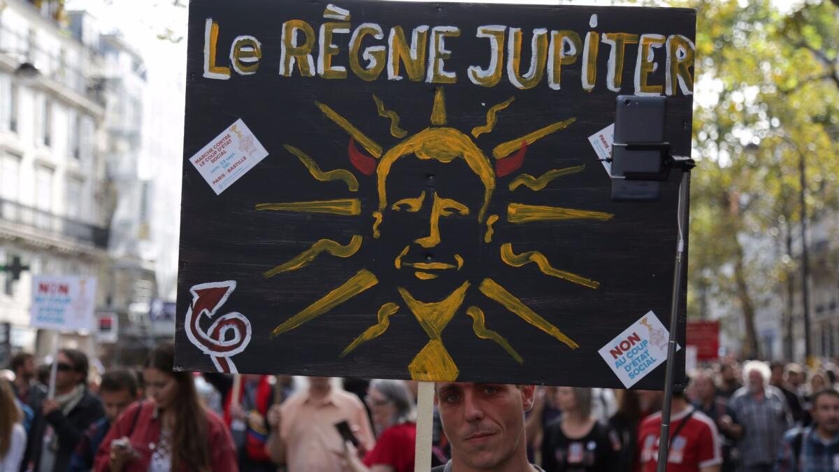 A demonstrator holds a sign reading "The reign of Jupiter" during a Sept. 23, 2017, protest in Paris by a leftist parliamentary group over the French government's labor reforms.