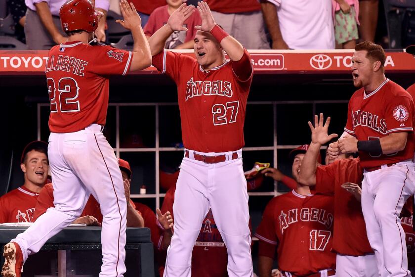 Outfielders Mike Trout (27) and Kole Calhoun (56) congratulate Conor Gillaspie after his two-run home run put the Angels ahead of the Indians in the sixth inning.