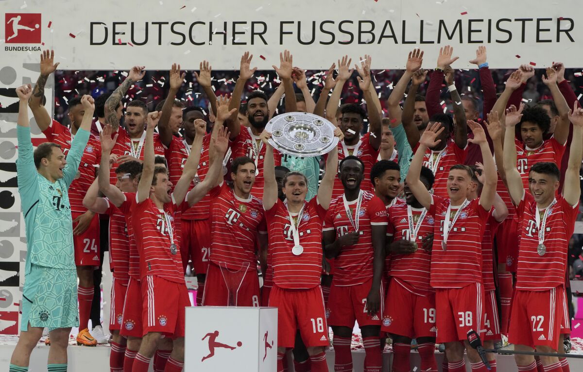 FILE - Bayern's players celebrate with the championship trophy after the German Bundesliga soccer match between Bayern Munich and Stuttgart, at the Allianz Arena, in Munich, Germany, Sunday, May 8, 2022. Bayern Munich will start its bid for a record 11th consecutive Bundesliga title with a potentially tricky game away at Europa League winner Eintracht Frankfurt after the season schedule was published Friday, June 17, 2022. (AP Photo/Michael Probst, File)