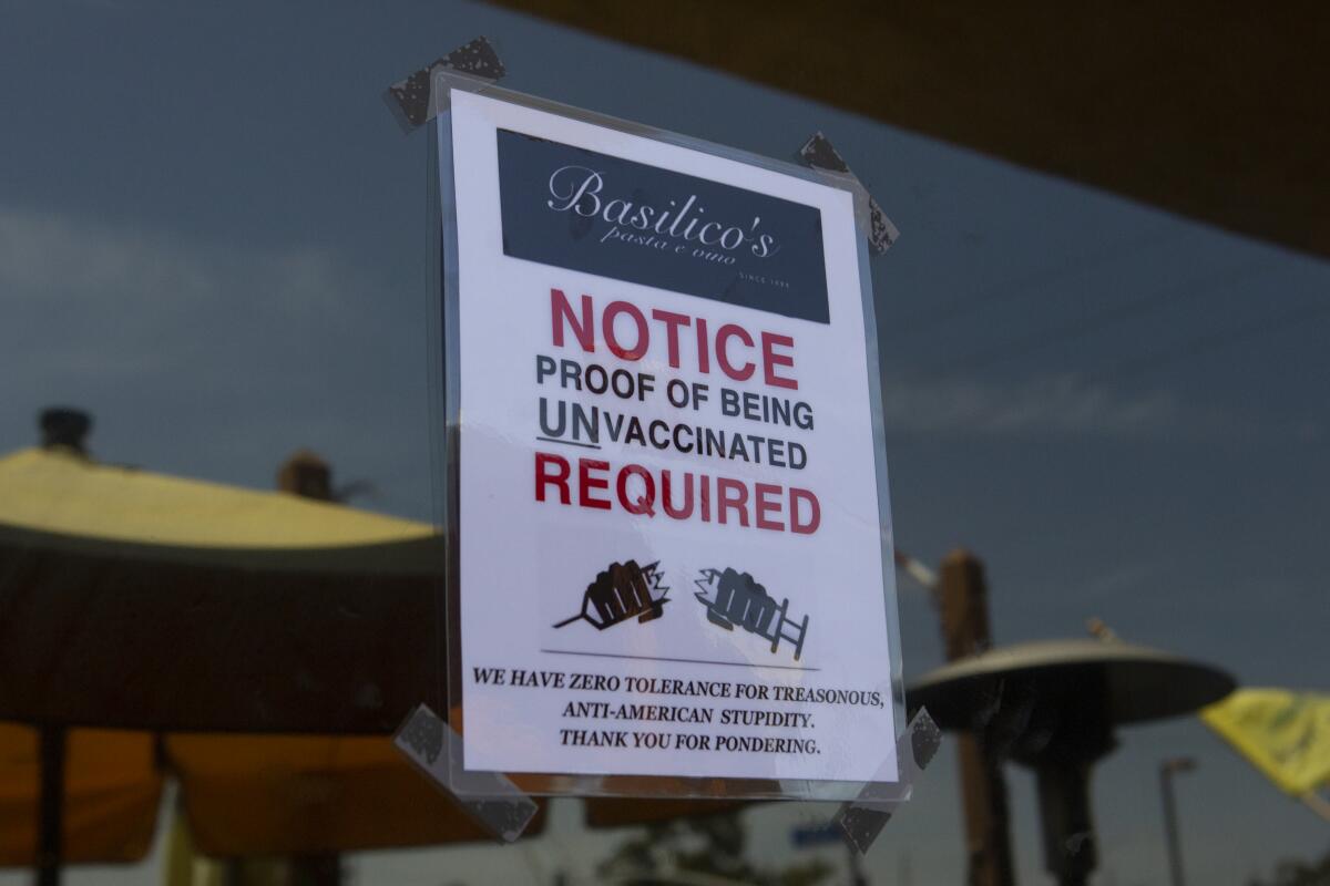 A restaurant sign requiring proof of non-vaccination