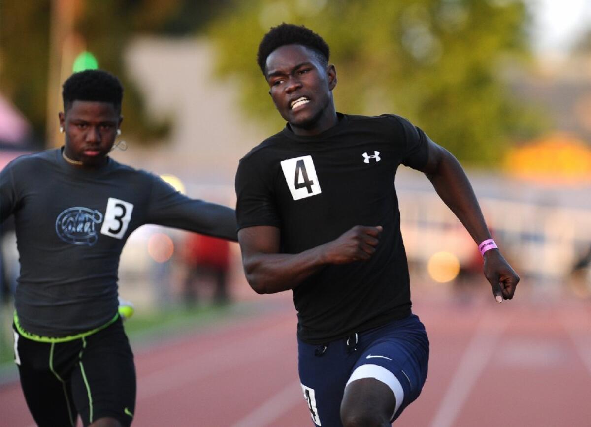Chatworth's Daniel Kamulali, right defeats Carson's Marquel Angelo in the 100 meters during the City track finals at Birmingham High School in Van Nuys on May 26.