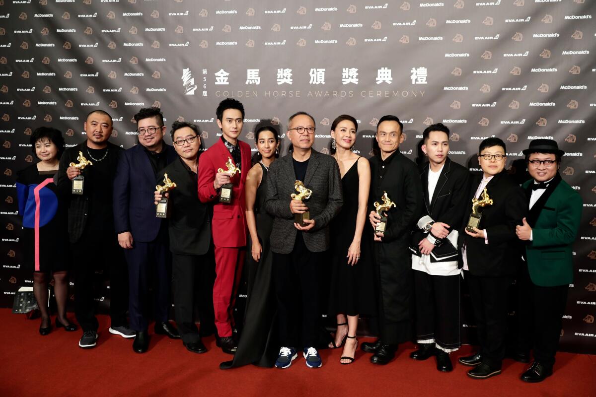Taiwanese film director Chung Mong-hong, center, and the cast of his movie "A Sun" pose for photographs after winning the Best Narrative Feature award at the 56th Golden Horse Awards ceremony in Taipei, Taiwan, on Nov. 23, 2019. The film awards established in 1962 are presented to filmmakers working in Chinese-language cinema.