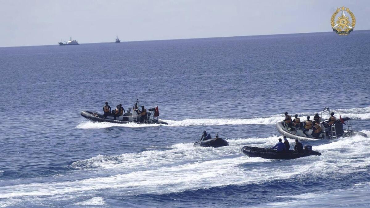 This handout photo provided by the Philippines Armed Forces shows Filipino navy personnel collecting remains of food packs that were floating in the seas of Second Thomas Shoal, on Sunday, May 19, 2024. The Philippine military chief on Tuesday said the Chinese coast guard seized one of four food packs dropped by a plane for Filipino navy personnel at a territorial outpost that has been surrounded by Chinese vessels in the disputed waters of the South China Sea. (Armed Forces of the Philippines via AP)