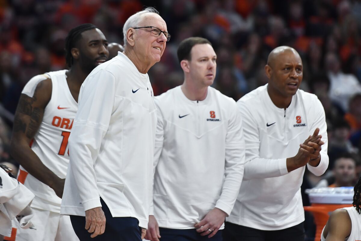 Syracuse coach Jim Boeheim, assistant Gerry McNamara, and associate coach Adrian Autry watch from the sideline.