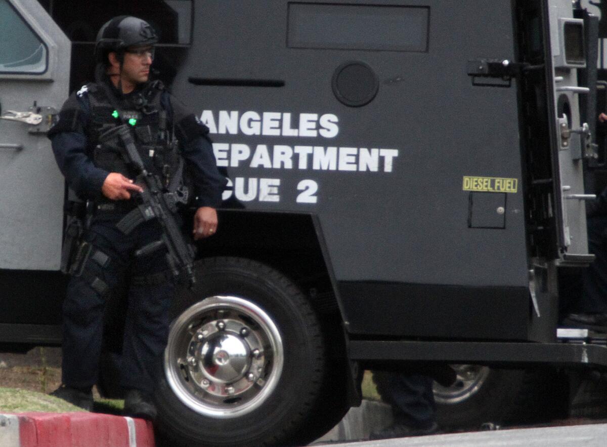 LAPD SWAT team members take positions around home on Meyler Street in San Pedro after a man locked himself inside the home, which is within a block of a private high school and Cabrillo Avenue Elementary School.
