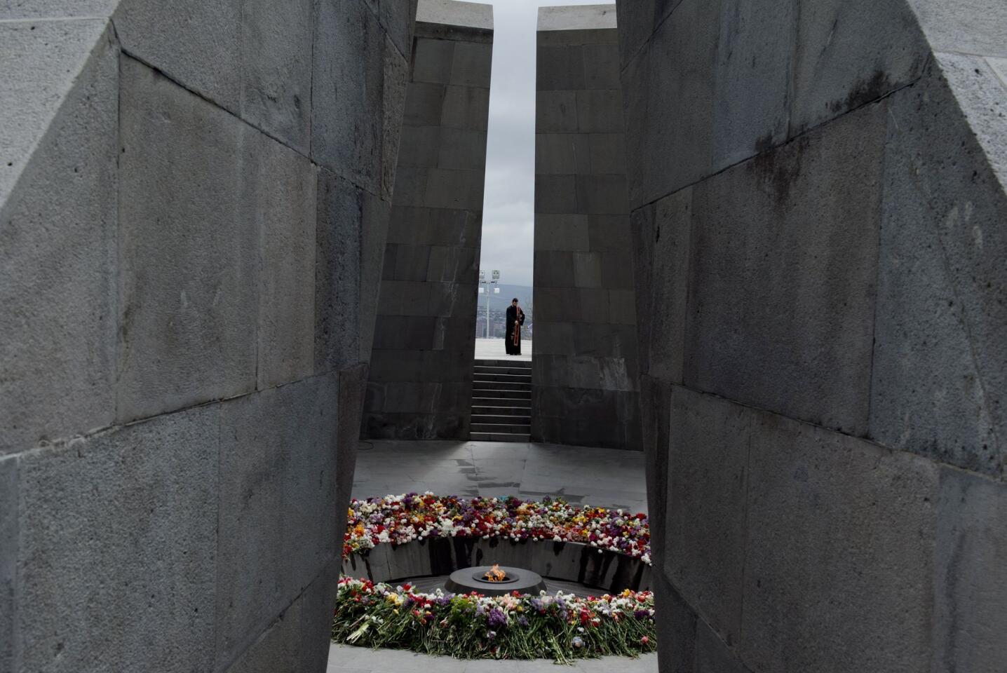 A clergyman of the Orthodox church walks toward the eternal flame during a ceremony April 24, 2015, at the Genocide Memorial in Yerevan, Armenia.