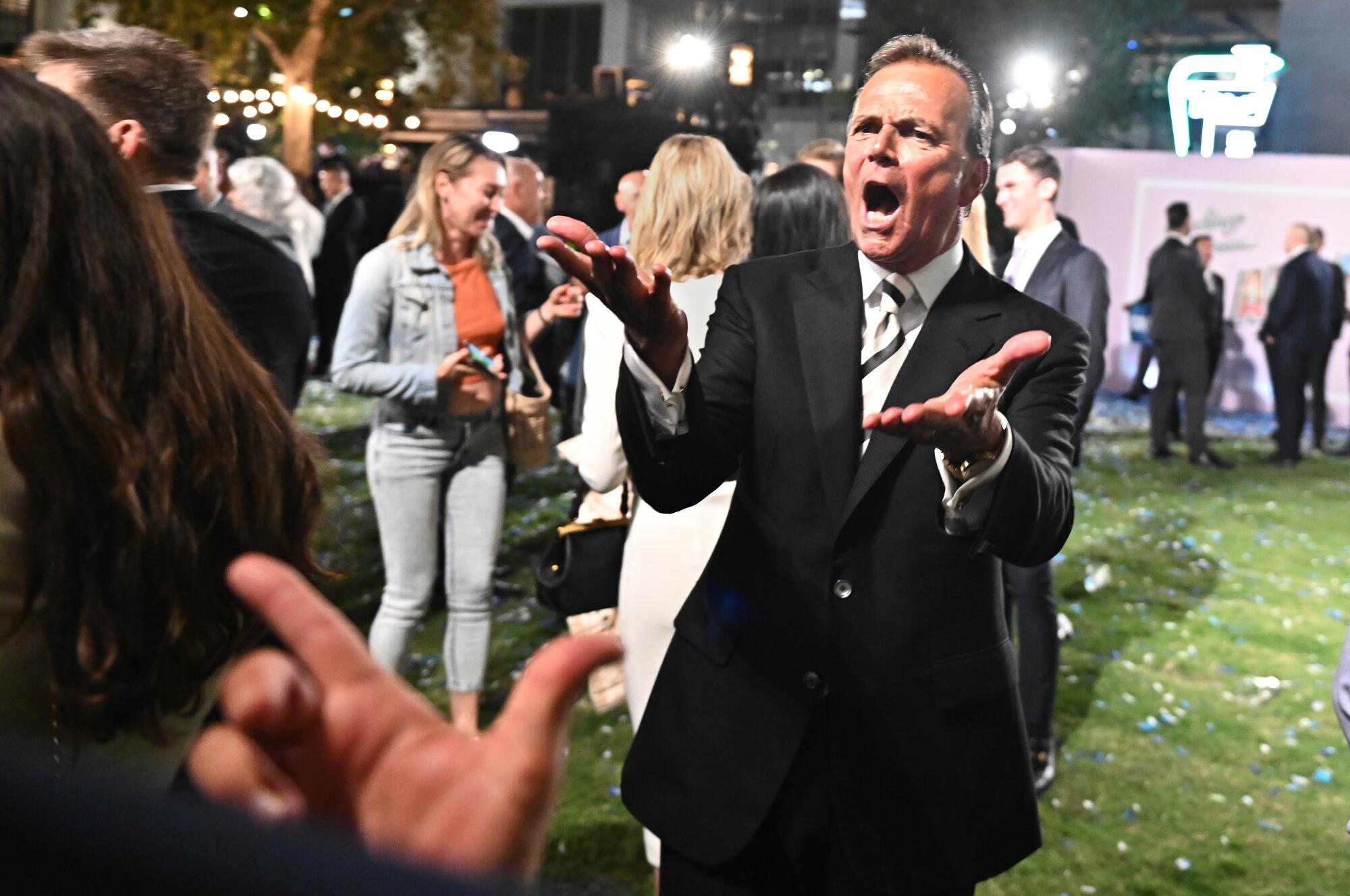 Rick Caruso holding out his hands as he greets supporters at an election event