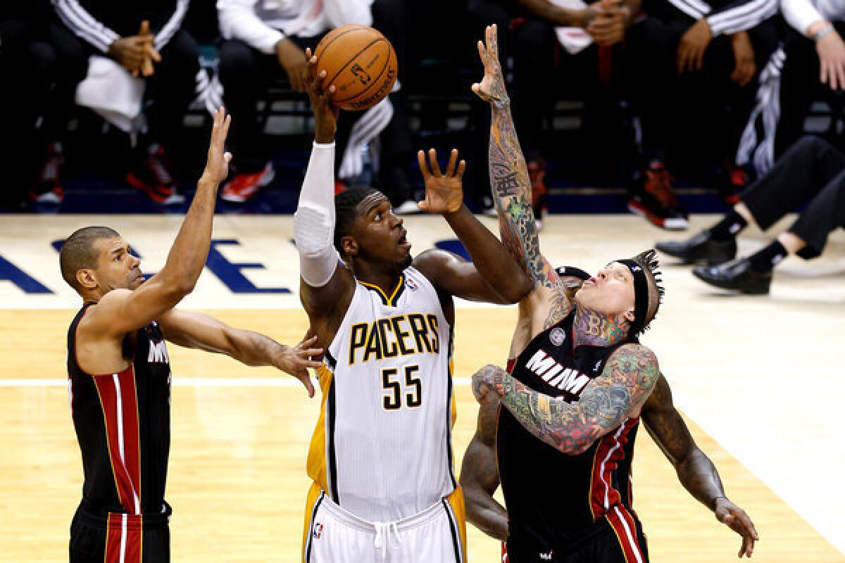 Indiana Pacers' Roy Hibbert (55) attempts a shotover the Miami Heat's Chris Andersen, right.