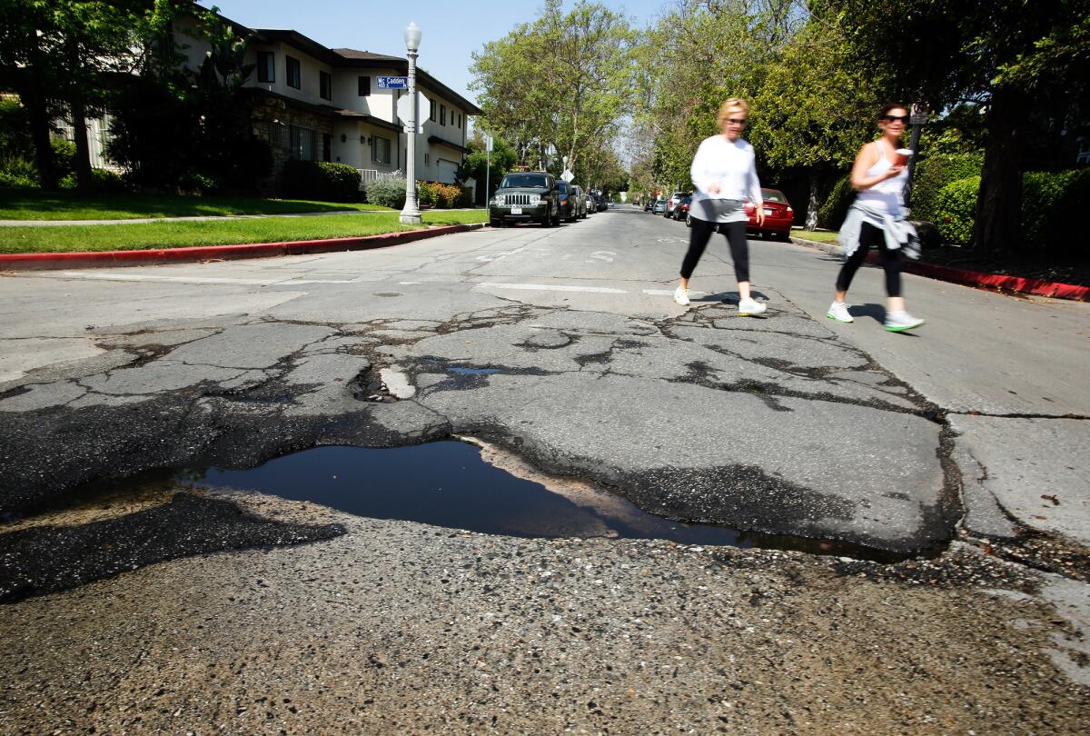 Mayor Eric Garcetti should concentrate on improving basic services -- like street repair -- before launching initiatives like the city's new Office of Immigrant Affairs. Above, a pothole in Hancock Park.