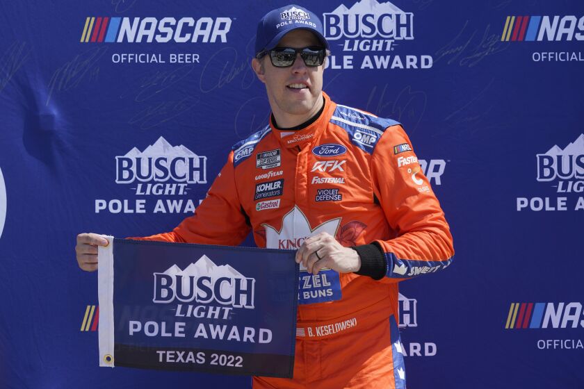 Brad Keselowski poses for photos after he took the pole position during qualifying for the NASCAR Cup Series auto race at Texas Motor Speedway in Fort Worth, Texas, Saturday, Sept. 24, 2022. (AP Photo/LM Otero)