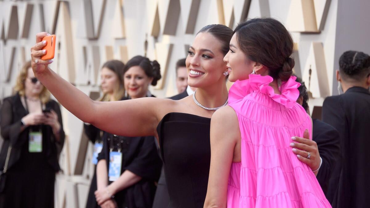 Ashley Graham and Gemma Chan pose for a selfie on the red carpet for the 91st Academy Awards.