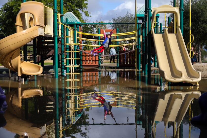 Los Angeles, CA - January 16: Lola Weiselman,7, from Pacific Palisades, luckily brought her rain boots, to help her brave the flooded Kenneth Hahn Park Playground, following a weekend of rain in southern California, on the federal holiday celebrating the birthday of Dr. Martin Luther King, Jr., inside Kenneth Hahn State Recereational Area, in Los Angeles, CA, Monday, Jan. 16, 2023. (Jay L. Clendenin / Los Angeles Times)