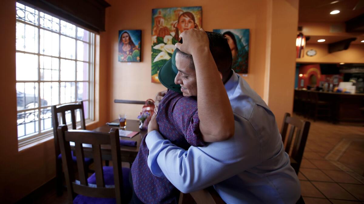 Juan Casas, 28, right, hugs Gloria Plaza, 32, a fellow participant in the Deferred Action for Childhood Arrivals program, at Casa Fina Restaurant and Cantina in Boyle Heights. The Trump administration announced Tuesday that it will end DACA.