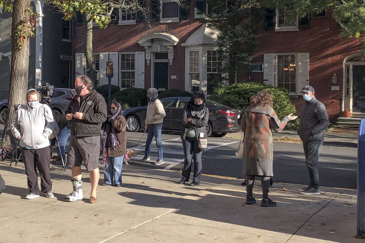Voters wait in line outside the Bucks county government building in Doylestown, Pa., a suburb of Philadelphia, on Monday, Nov. 2, 2020. Some said they received word that their mail-in ballots had problems and needed to be fixed in order to count. (AP Photo/Mike Catalini)