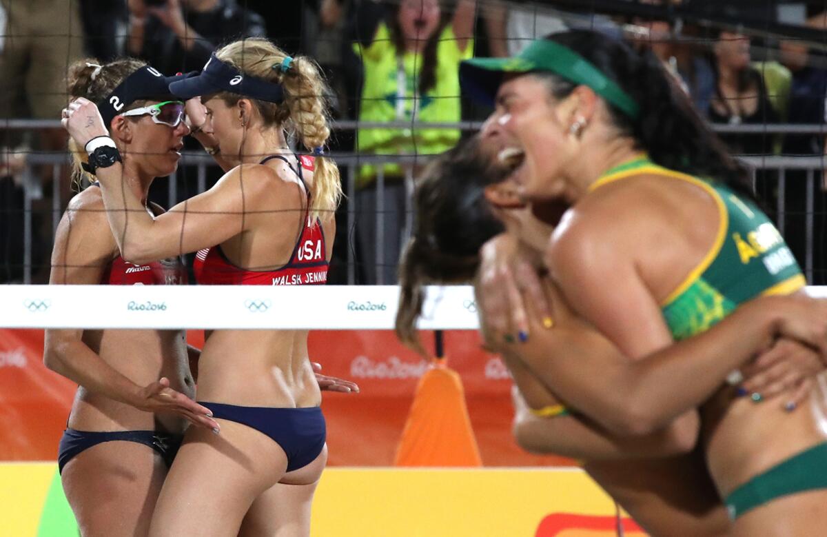 Kerri Walsh Jennings, right, and April Ross console each other as Brazil celebrates a 2-0 win over the U.S. in a Women's Beach Volleyball semifinal.