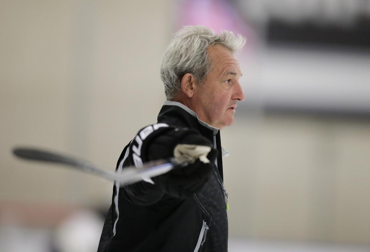 Kings Coach Darryl Sutter watches his team practice Friday in El Segundo as the team got its first workouts of training camp in after winning the Stanley Cup last season.