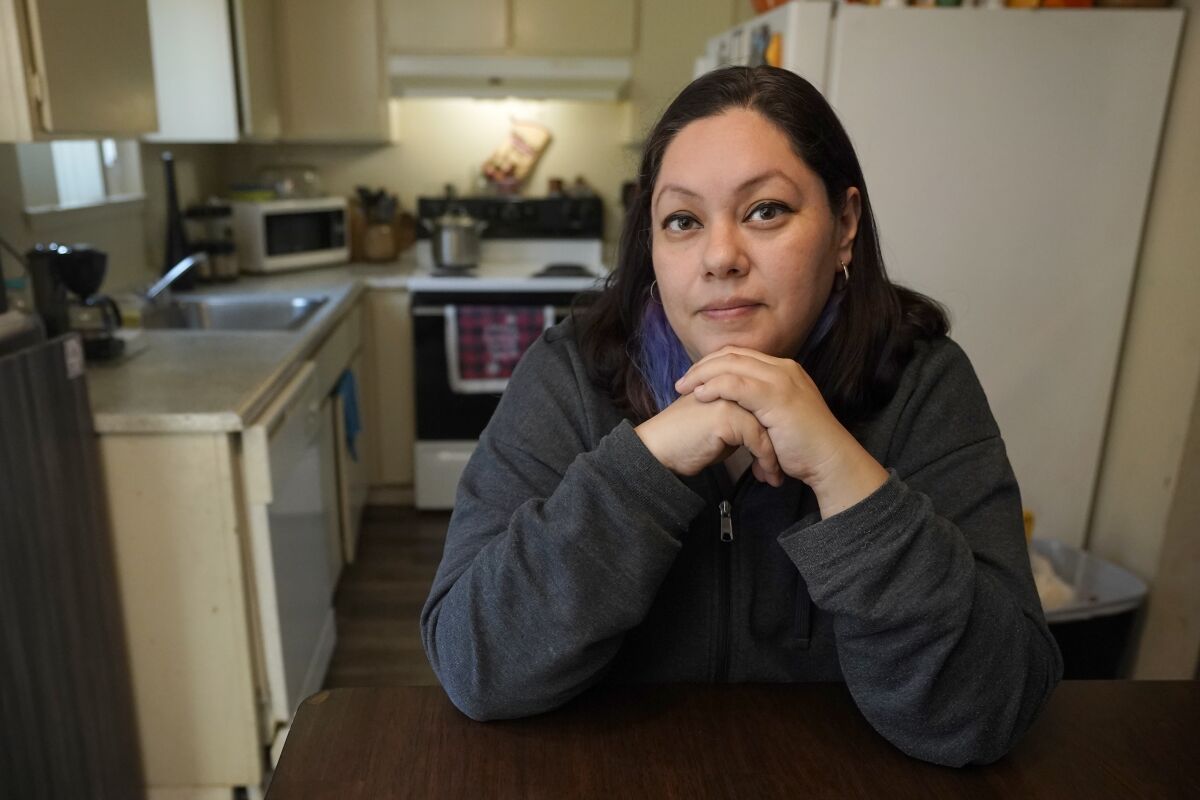 Crystal Orozco poses for a photo at the apartment she lives in with her husband and children in Carmichael, Calif., Monday, Feb. 7, 2022. When Orozco got sick from the coronavirus the month before she missed nearly two weeks' worth of her salary as a shift leader at a fast food restaurant. The California Legislature is expected to vote on a bill that would require most companies to give employees, like Orozco, up to two weeks of paid time off if they get sick from the coronavirus, a law that would be retroactive to Jan. 1. (AP Photo/Rich Pedroncelli)