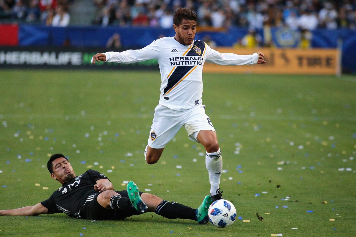 Roger Espinoza #17 of Sporting Kansas City and Jonathan dos Santos #8 of the Los Angeles Galaxy fight for control of the ball during a game at StubHub Center on April 8, 2018 in Carson, California.