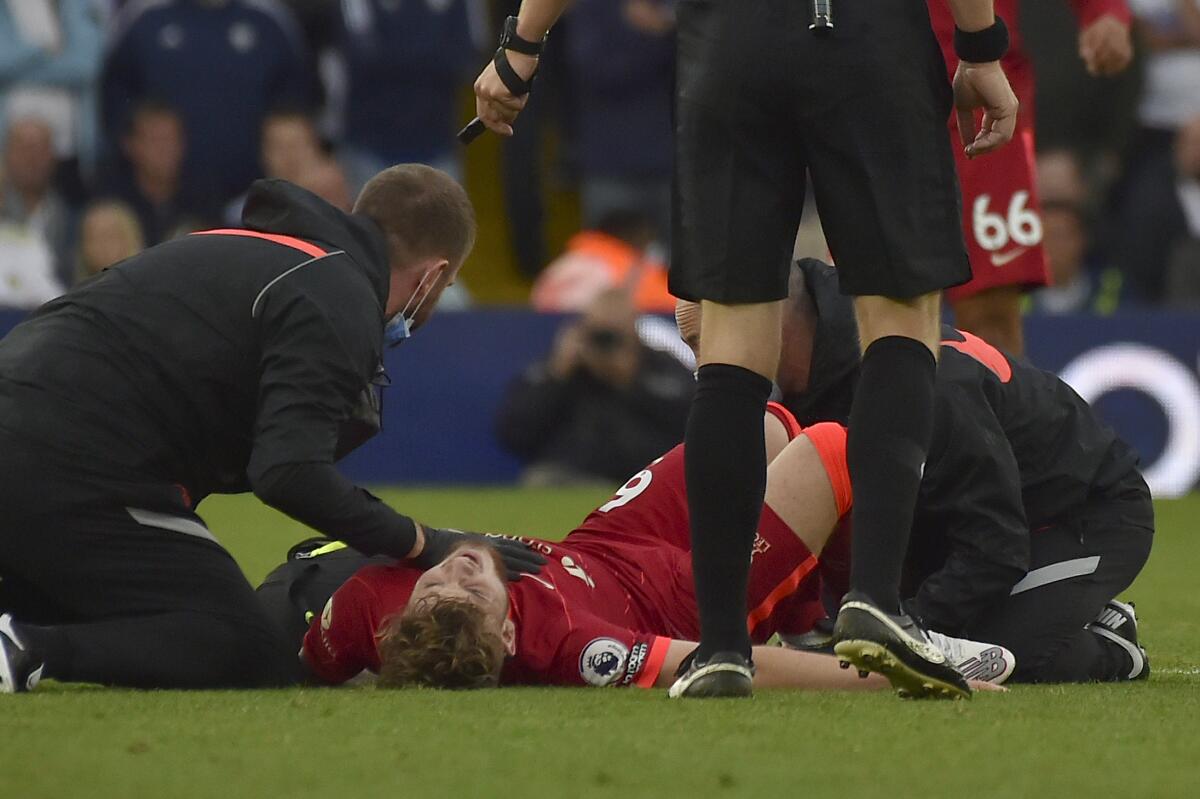 Liverpool's Harvey Elliott is assisted after he got injured in a clash with Leeds United's Pascal Struijk during the English Premier League soccer match between Leeds United and Liverpool at Elland Road, Leeds, England, Sunday, Sept. 12, 2021. (AP Photo/Rui Vieira)