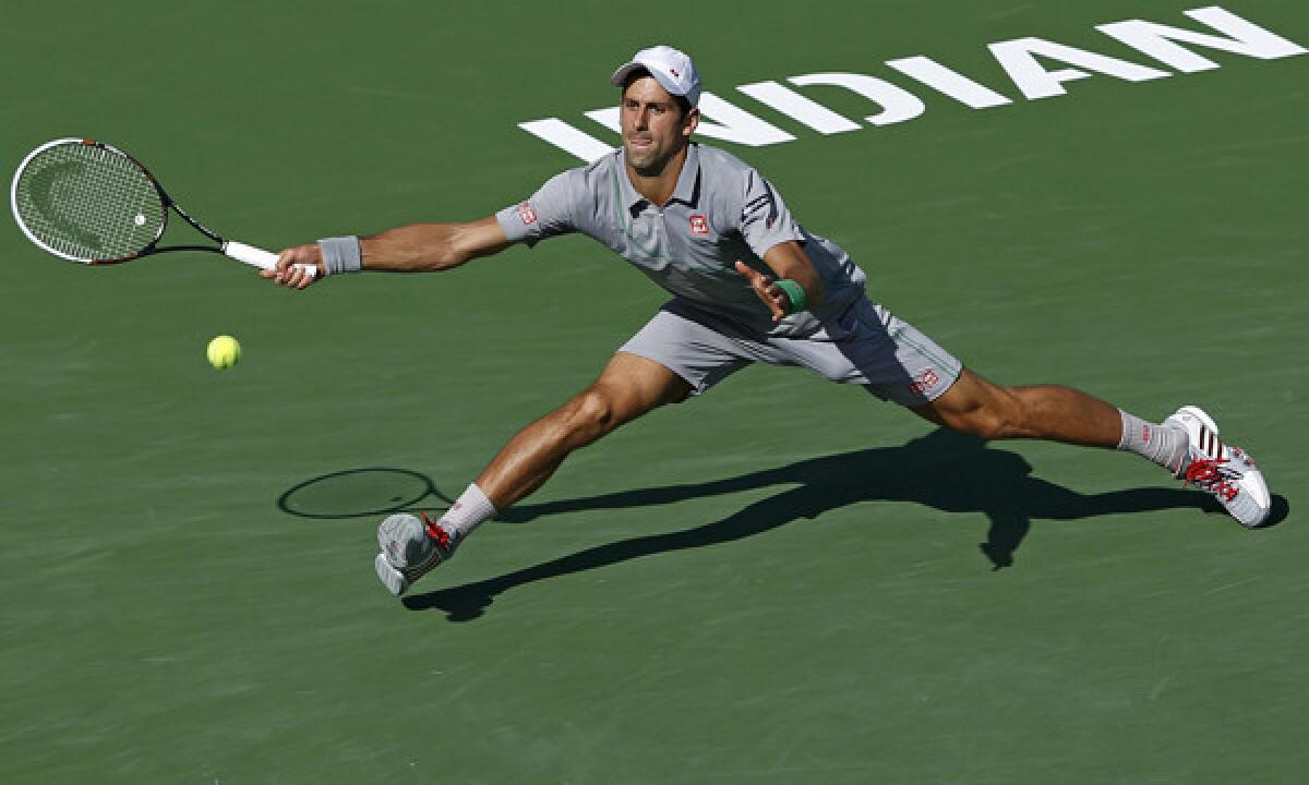 Novak Djokovic stretches to return a shot during his semifinal victory over John Isner at the BNP Paribas Open in Indian Wells on Saturday. Djokovic will play Roger Federer in the tournament final Sunday.