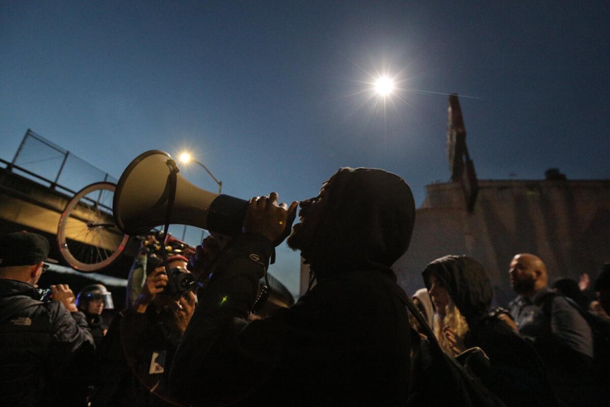 A protester speaks through a bullhorn during a march protesting the killing of unarmed black men by police Dec. 13, 2014, in Oakland. The march was one of many held nationwide.