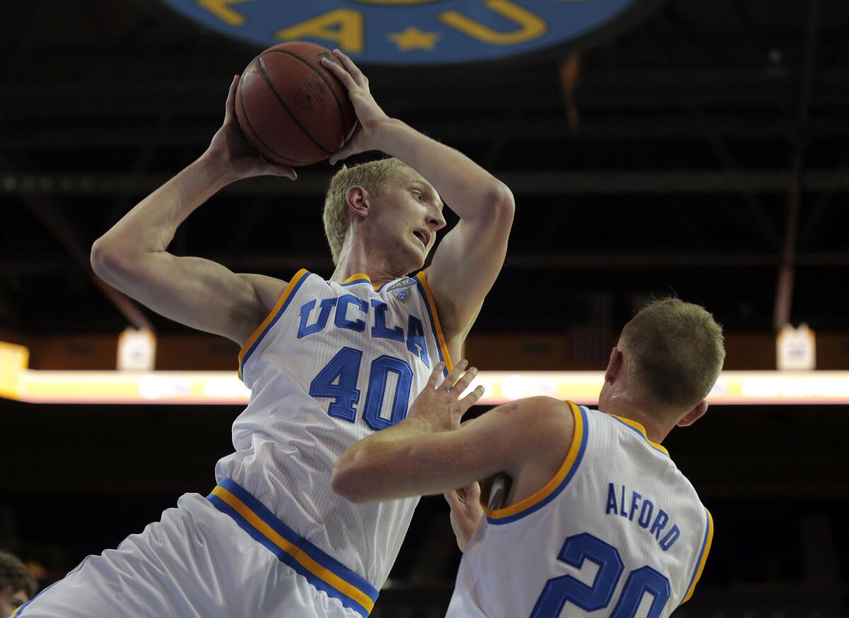 UCLA center Thomas Welsh (40) pulls down a rebound in front of Bryce Alford during a game against Pepperdine.
