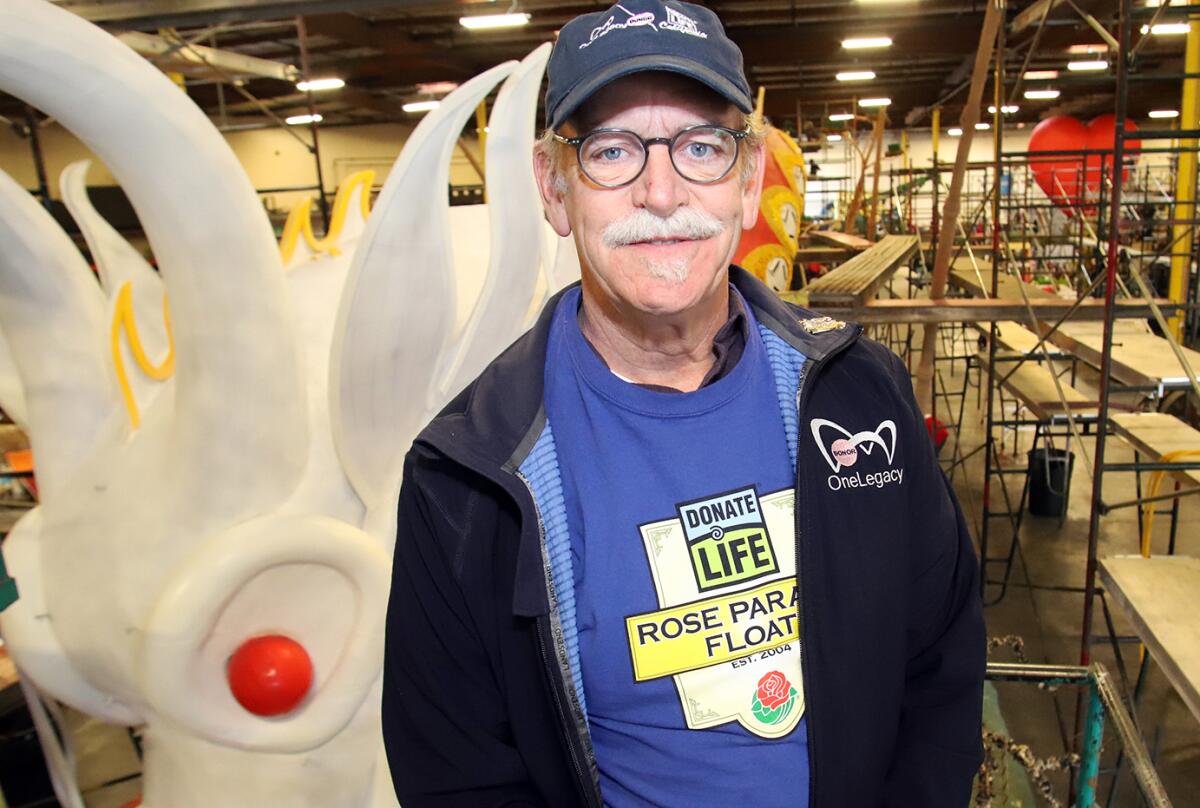 Tom Mone, the chief external affairs officer of OneLegacy, poses with Donate Life's "Lifting Each Other Up" float.