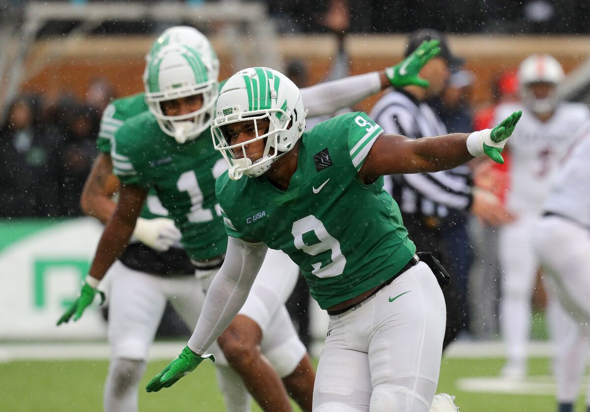 North Texas' Grayson (9) and Gabriel (11) Murphy celebrate after sacking UTSA quarterback Josh Adkins.