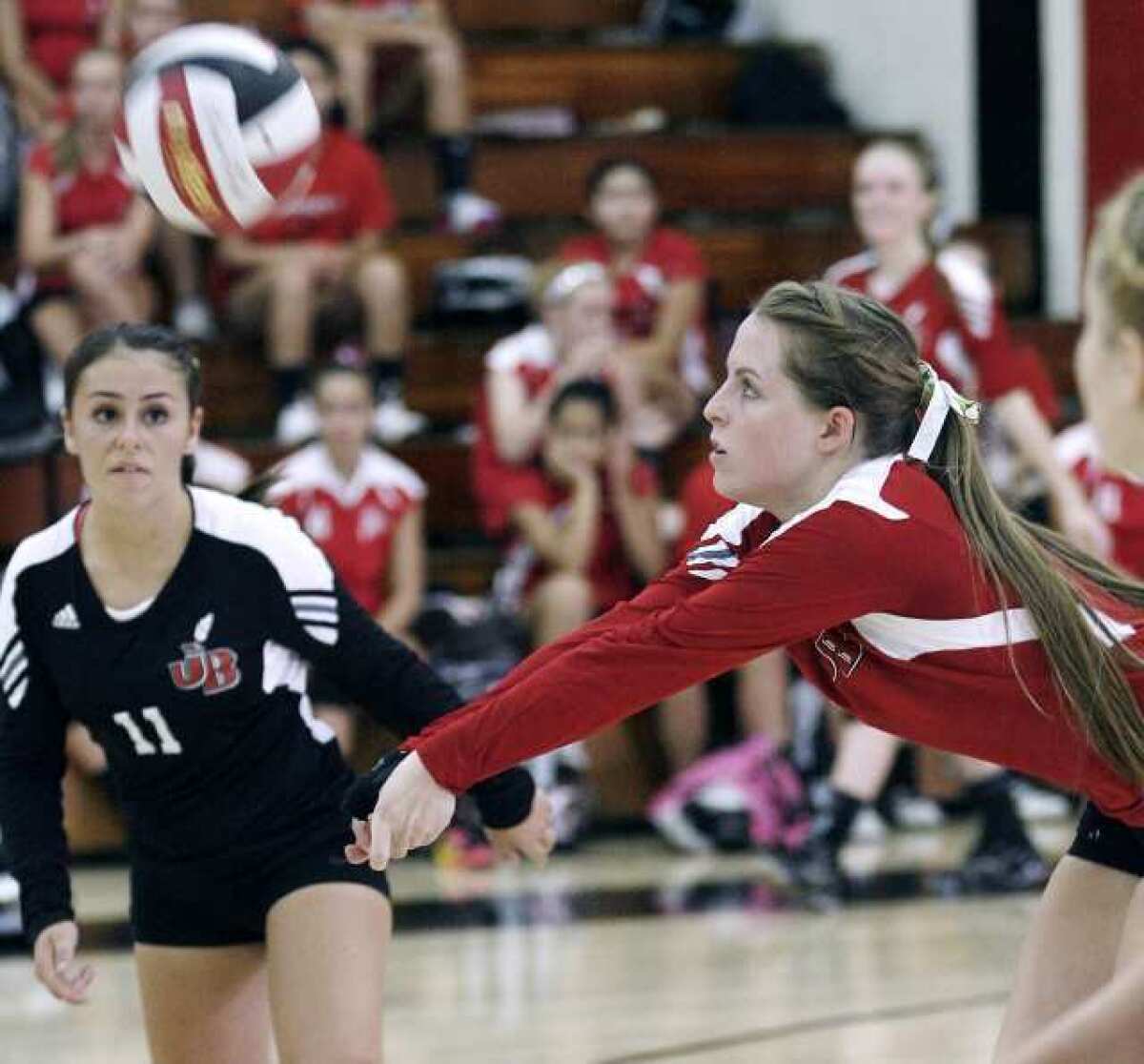 With Burroughs High School's Daniela Gonzalez, left, keeping a close eye on the action, Tori Adams digs the ball during a match with Glendale High.