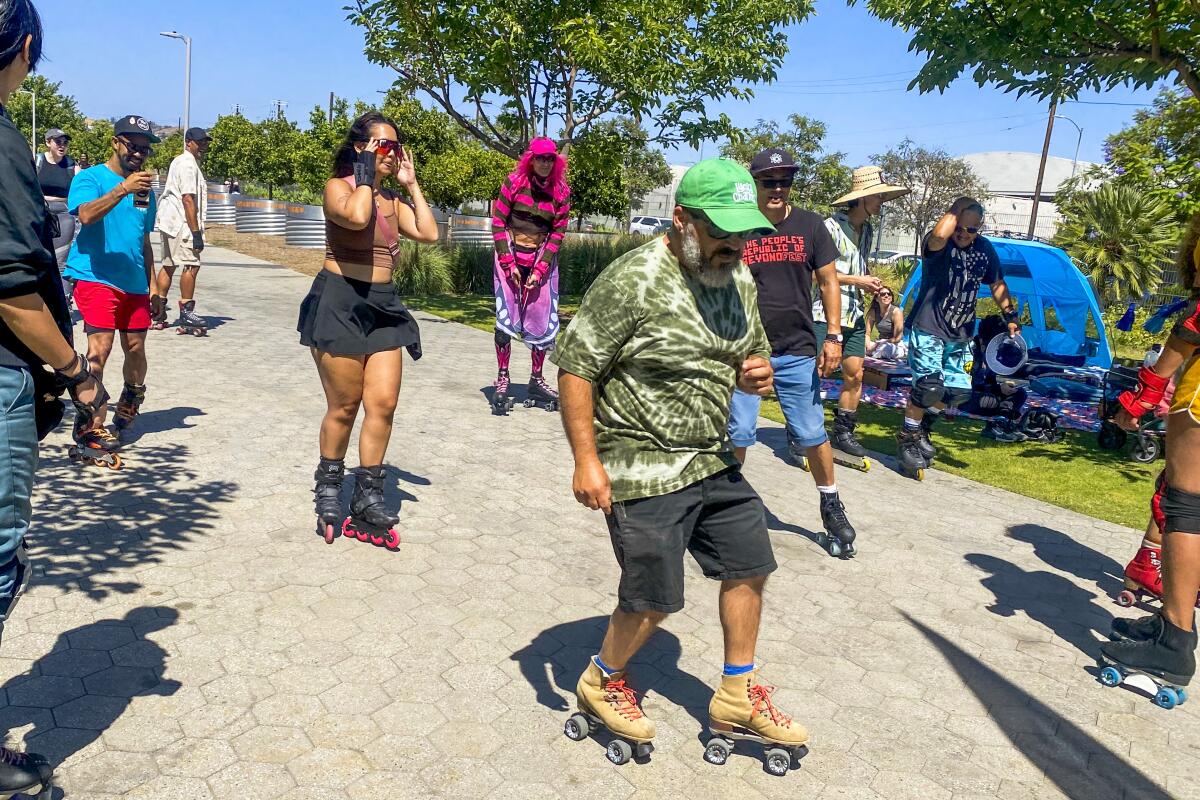 Men and women roller skate in the sun.
