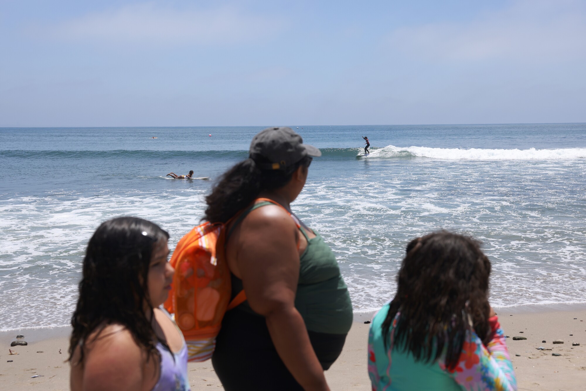 Cecilia Chavez walks with Emily Macias and Camila Aguayo while watching the Queen of the Point surf competition.