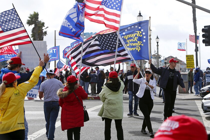 Pro-Trump protesters rally Saturday afternoon at Pier Plaza in downtown Huntington Beach.