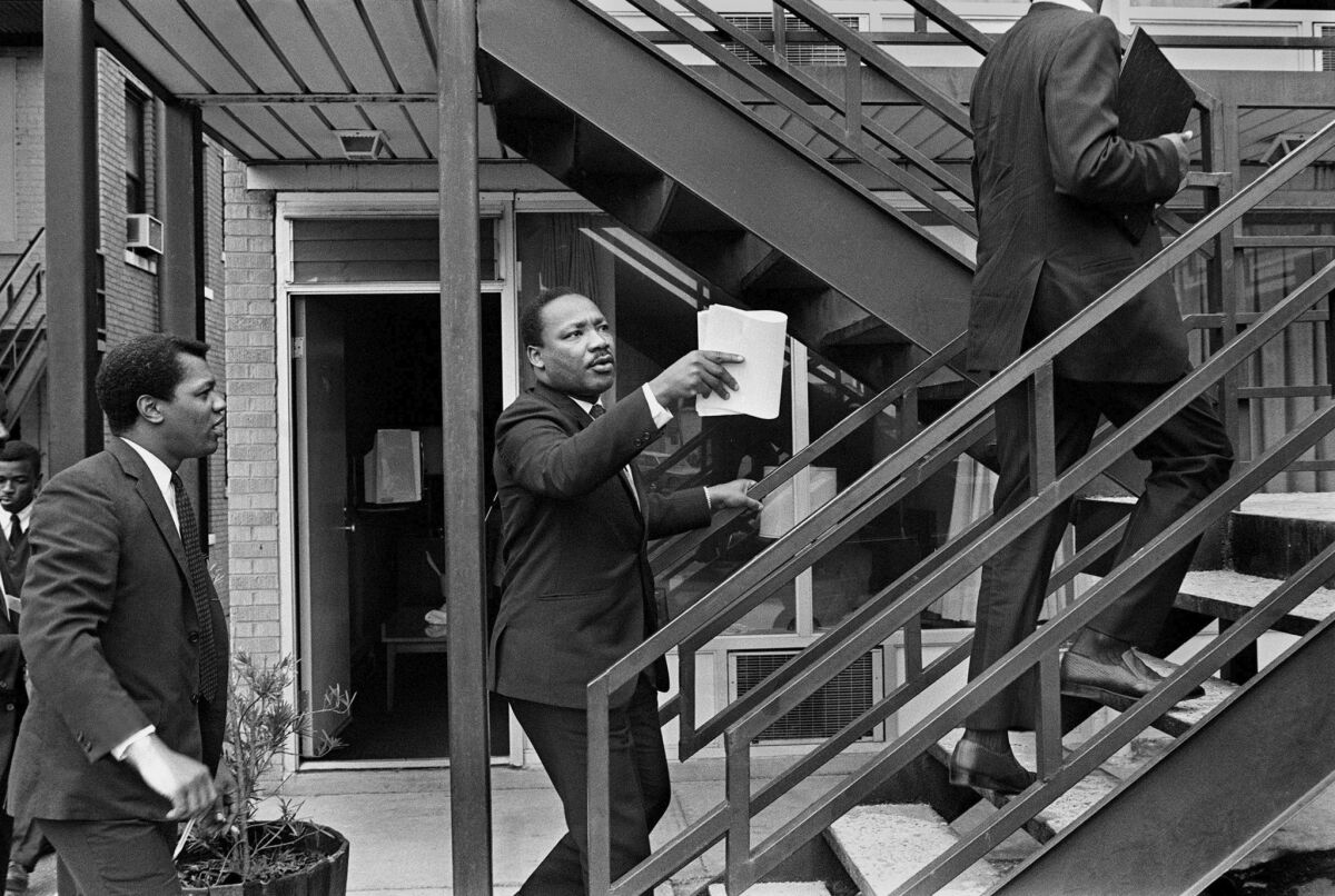 A day before he was shot, King and his aides walk at the Lorraine Motel, discussing the restraining order King had just received barring him from leading another march in Memphis without court approval.