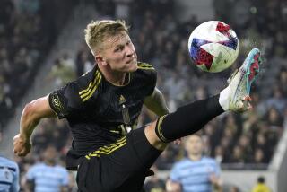 Los Angeles FC midfielder Mateusz Bogusz, right, kicks the ball during the second half.