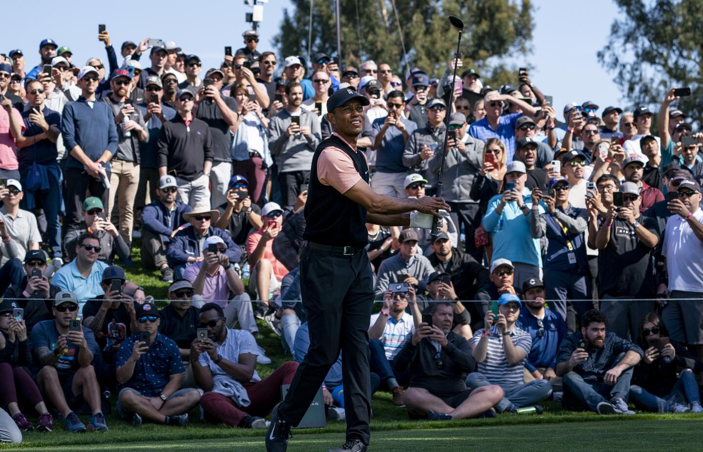 A large crowd follows Tiger Woods as he hits from the fifth tee during the first round of the Genesis Invitational at Riviera Country Club on Feb. 13, 2020.
