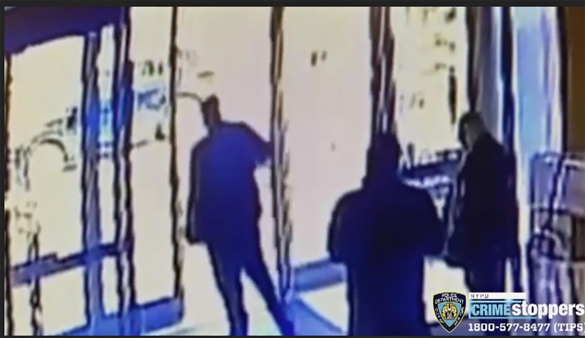 An image from a surveillance video shows a doorman closing an apartment building's front door.