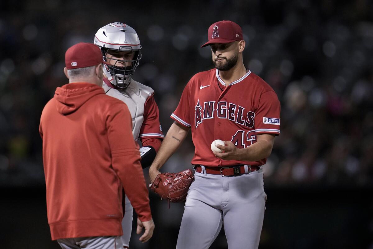 Angels pitcher Patrick Sandoval hands the ball to manager Phil Nevin as he is pulled from the game.