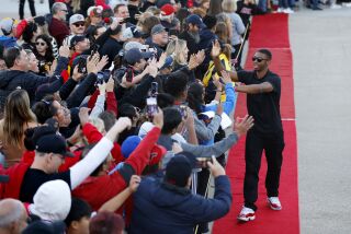 San Diego, CA - April 8: San Diego State's Lamont Butler high fives fans as he walk in the red carpet into Snapdragon Stadium for a celebration of the Aztecs which made it to the championship game in the NCAA tournament on Saturday, April 8, 2023. (K.C. Alfred / The San Diego Union-Tribune)