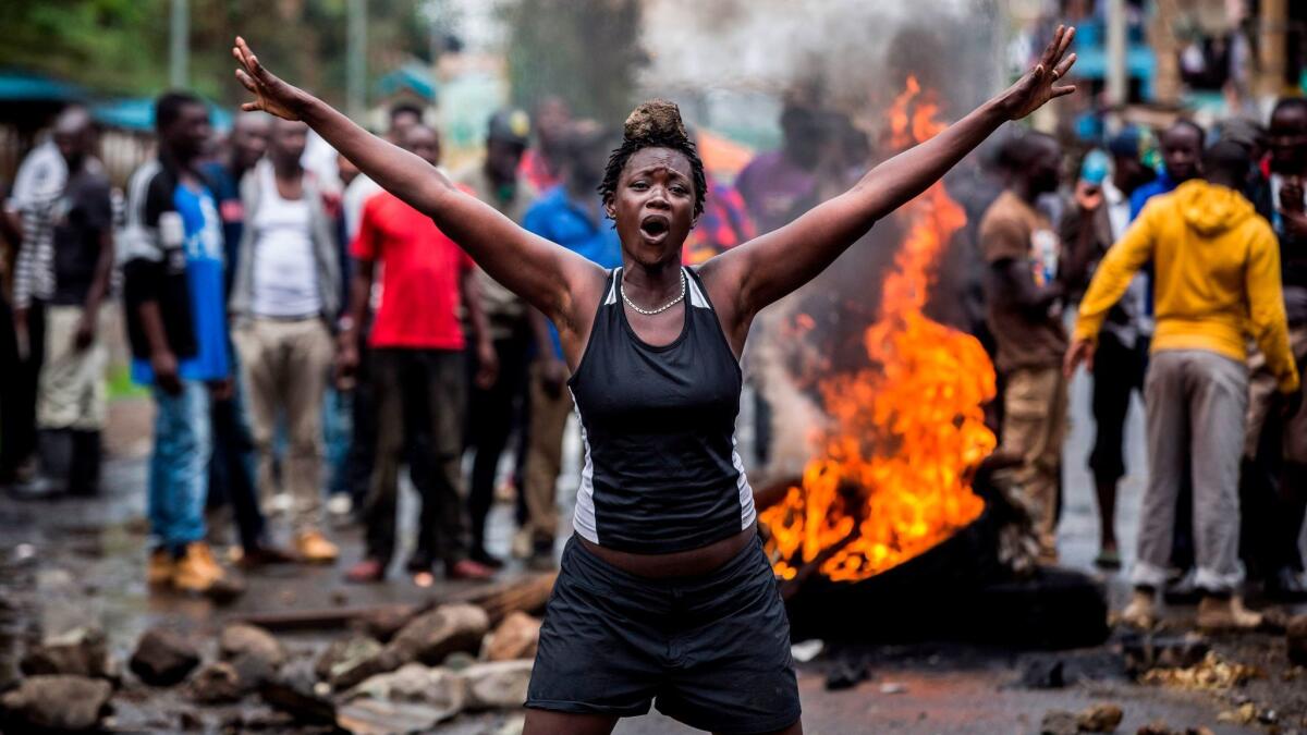 An opposition supporter in front of a burning barricade in Mathare slum district, in Nairobi, during Thursday's controversial repeat presidential election.