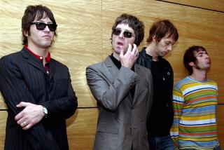 Band members of Oasis leaning against a wooden wall