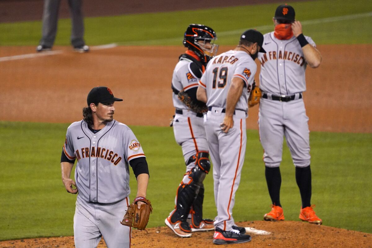 San Francisco Giants starting pitcher Jeff Samardzija, left, walks off the field after being taken out of the game during the fifth inning of a baseball game against the Los Angeles Dodgers Friday, Aug. 7, 2020, in Los Angeles. (AP Photo/Mark J. Terrill)