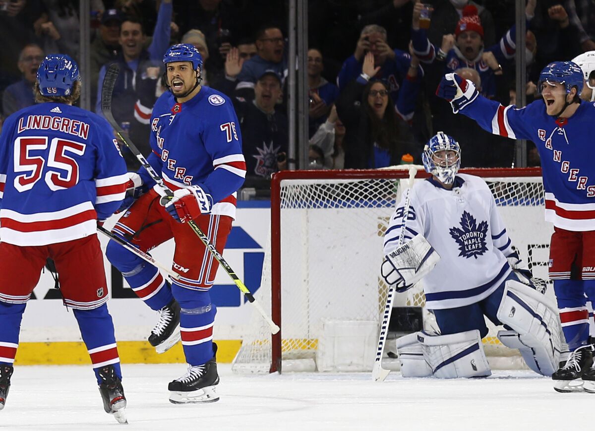 New York Rangers' Ryan Reaves (75) celebrates his goal on Toronto Maples Leafs goalie Jack Campbell with Ryan Lindgren (55) during the first period of an NHL hockey game Wednesday, Jan. 19, 2022, in New York. (AP Photo/John Munson)