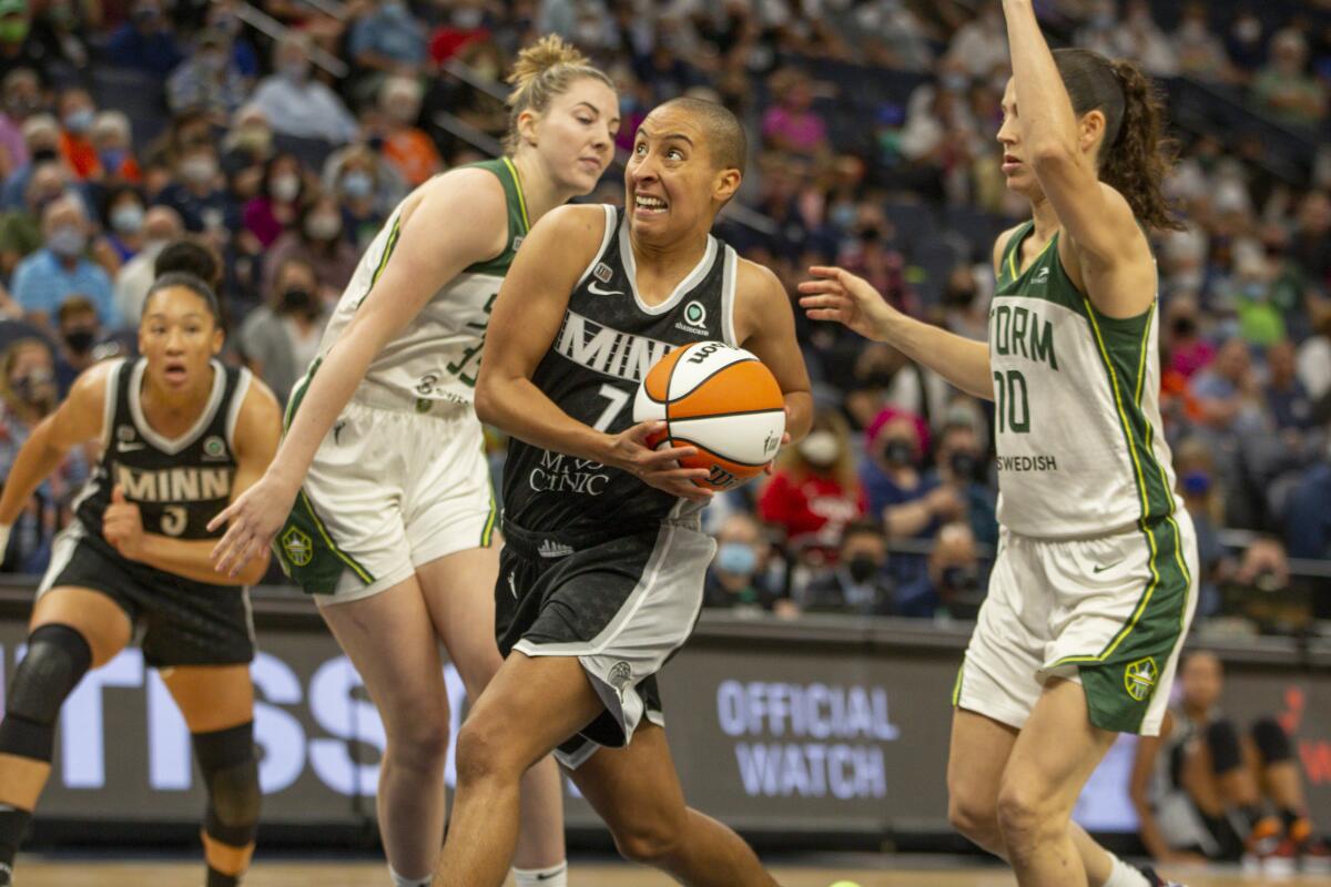 Minnesota Lynx guard Layshia Clarendon drives to the basket past Seattle Storm forward Breanna Stewart and guard Sue Bird.