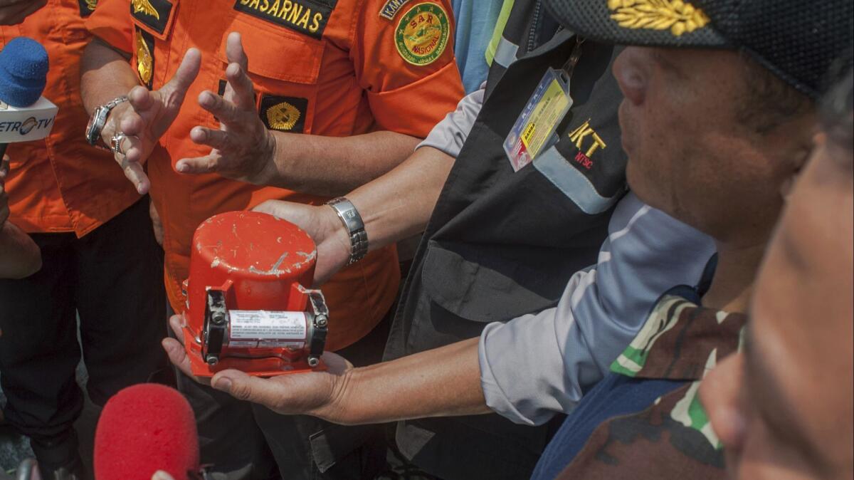 A member of Indonesia's National Transportation Safety Committee holds the flight data recorder from the crashed Lion Air jet Nov. 1.