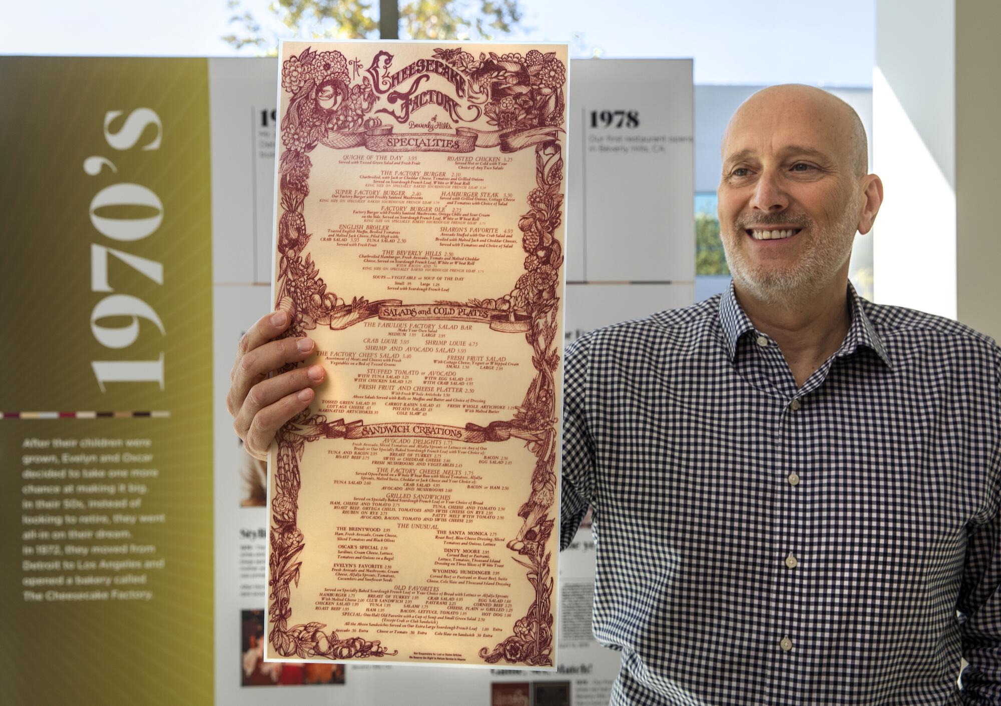David Gordon, president of The Cheesecake Factory, holds an original 1978 menu from the first location in Beverly Hills.