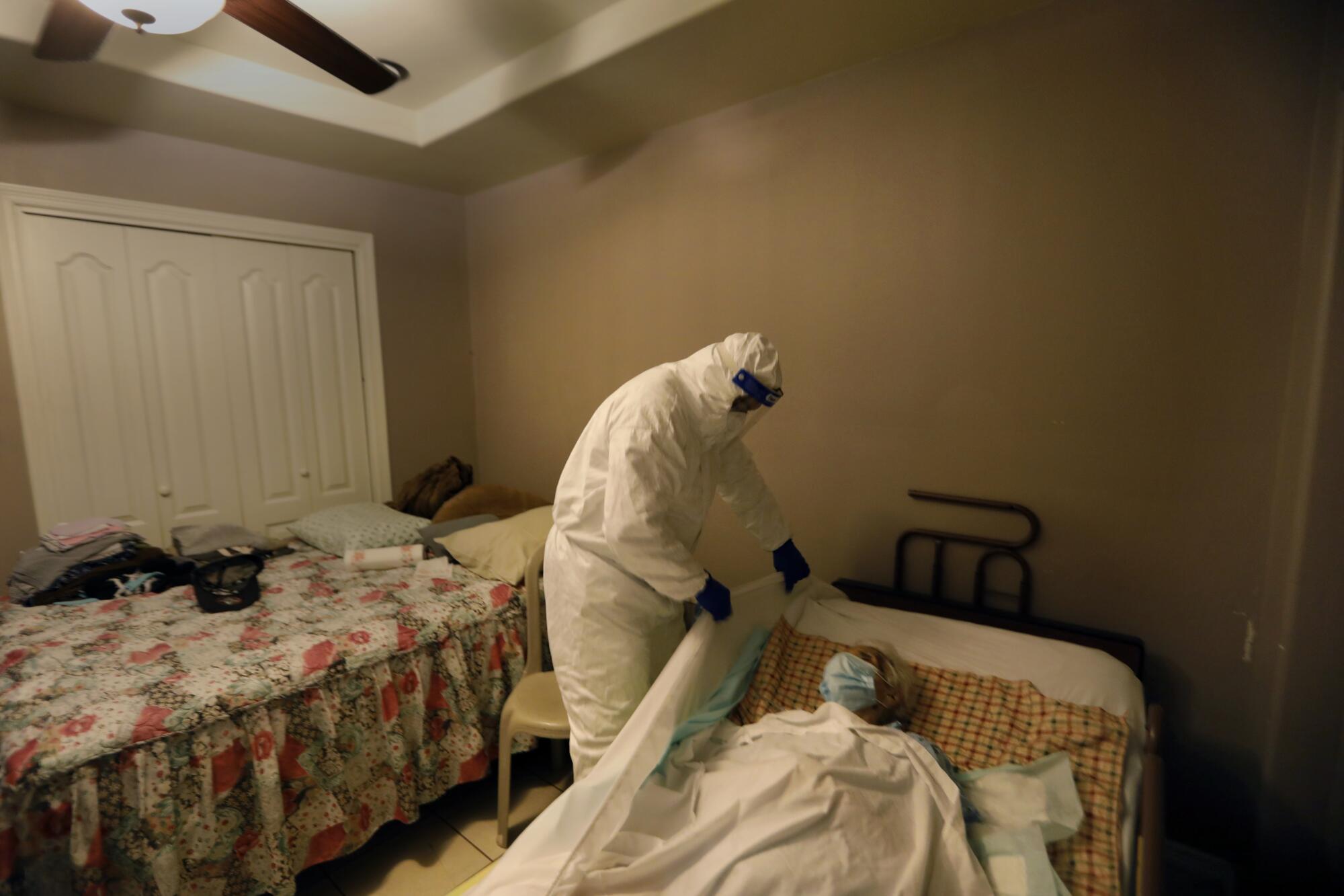 A worker prepares to remove a body in a home.